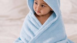 Little Luxuries by MIKI HOUSE di The Ritz-Carlton, Bali. Seorang bayi mengenakan ponco mandi premium MIKI HOUSE yang dibuat dari 100% katun untuk menjaga kehangatan dan kenyamanan si kecil setelah setiap mandi atau berenang.