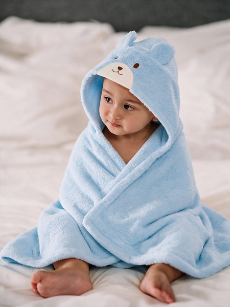 Little Luxuries by MIKI HOUSE di The Ritz-Carlton, Bali. Seorang bayi mengenakan ponco mandi premium MIKI HOUSE yang dibuat dari 100% katun untuk menjaga kehangatan dan kenyamanan si kecil setelah setiap mandi atau berenang.